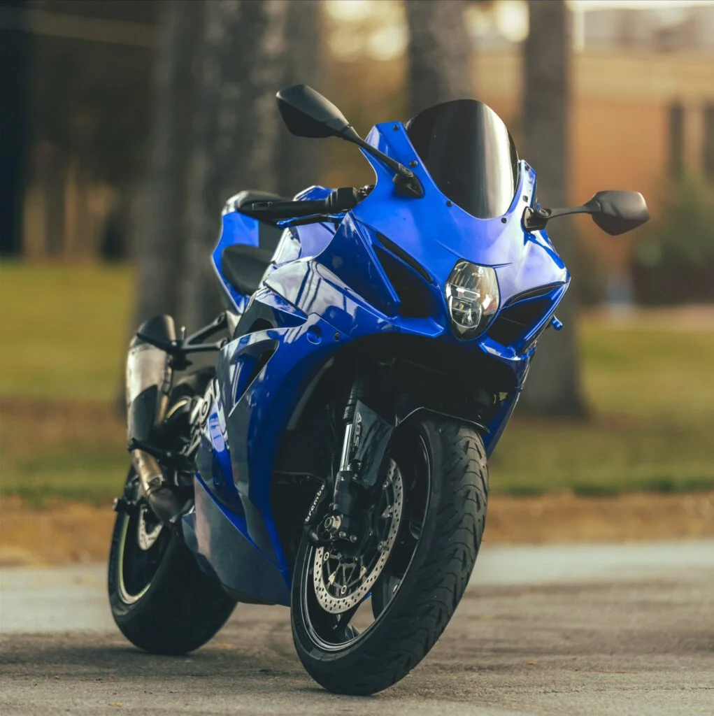 Blue sport motorcycle parked on a tree-lined street