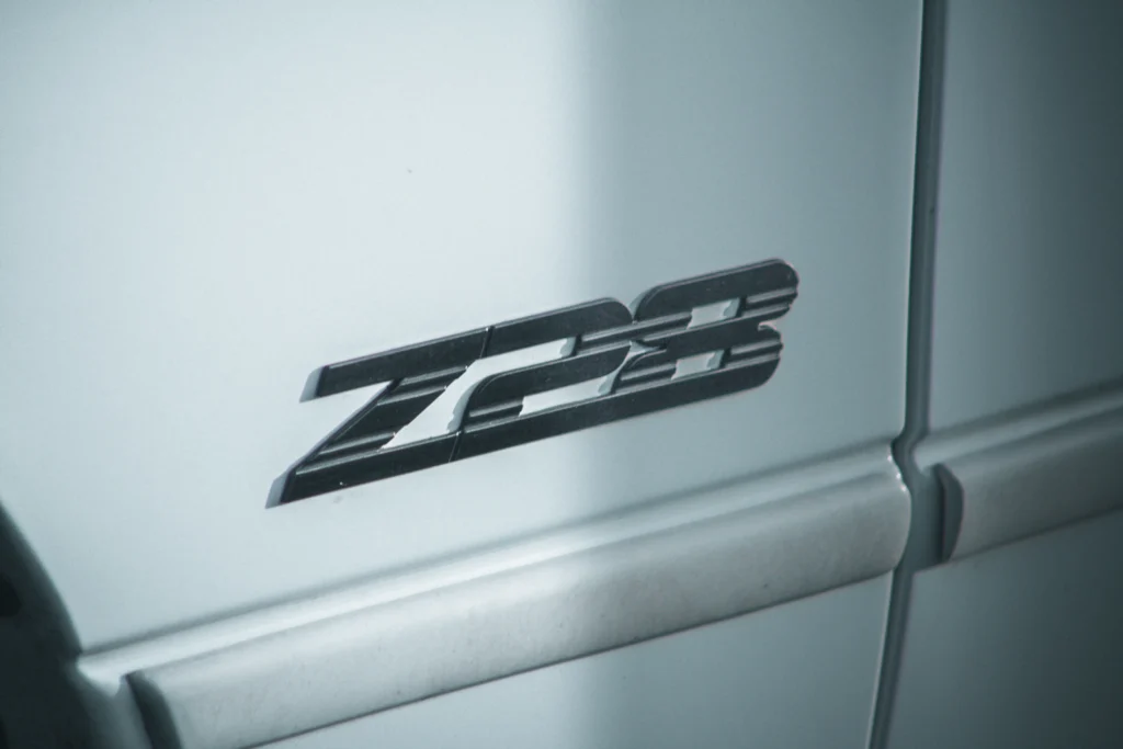 Close-up of a black Z28 badge emblem on a light-colored vehicle door panel.