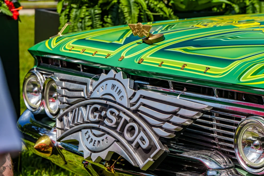 Green Chevrolet Impala front with detailed custom paint and a large Wingstop emblem on the grille