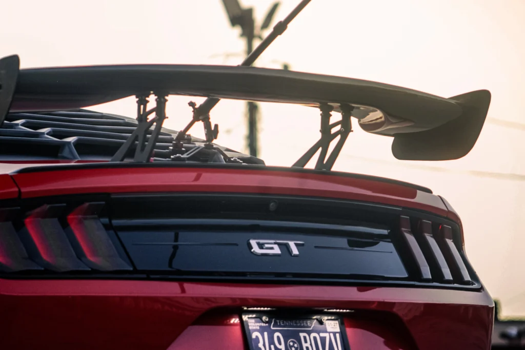 Rear wing and GT badge on red Ford Mustang with Tennessee license plate