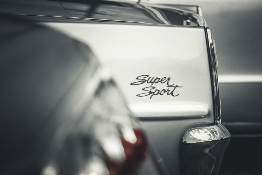 Close-up of a silver Chevrolet's rear quarter panel with a 'Super Sport' emblem and a chrome bumper corner