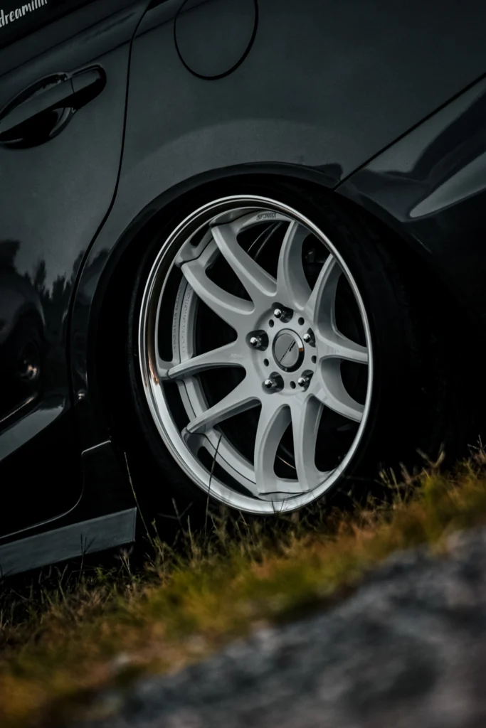 Close-up of white multi-spoke Work wheels on a Honda Civic, showing the rear passenger side wheel and part of the rear door