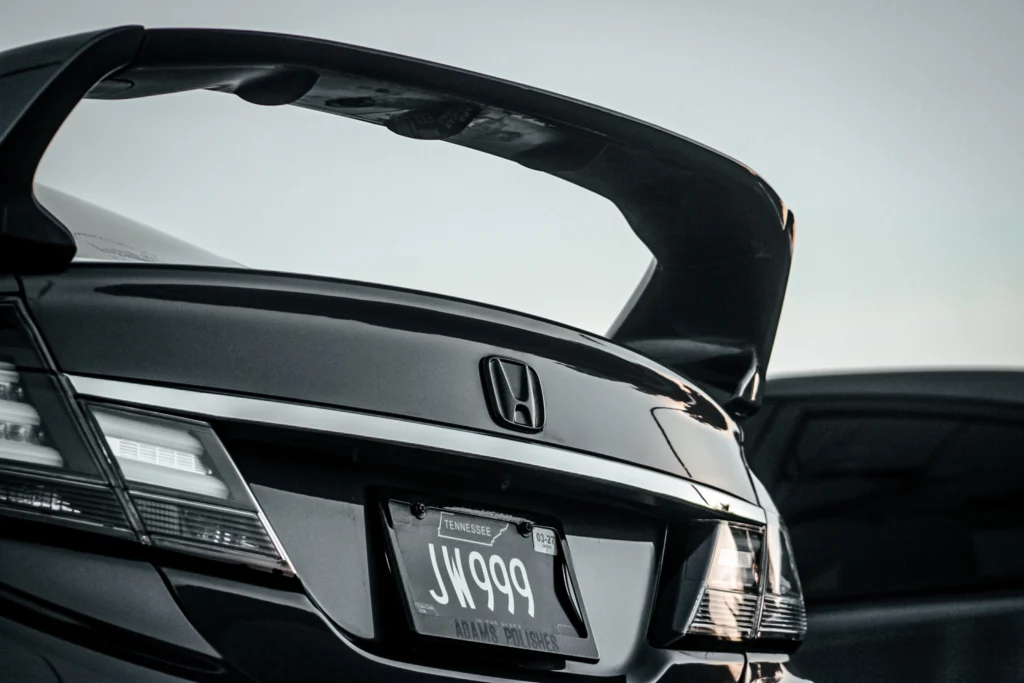 Rear section of a black Honda Civic with a raised spoiler and Tennessee license plate JW999