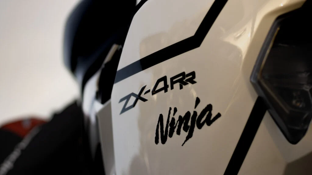 Close-up detail of white Kawasaki Ninja ZX-4RR motorcycle with black graphics and partial headlight visible