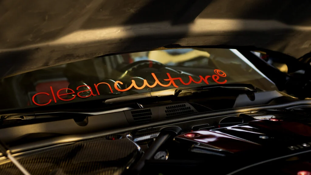 Windshield with red 'cleanculture' decal and visible car interior components