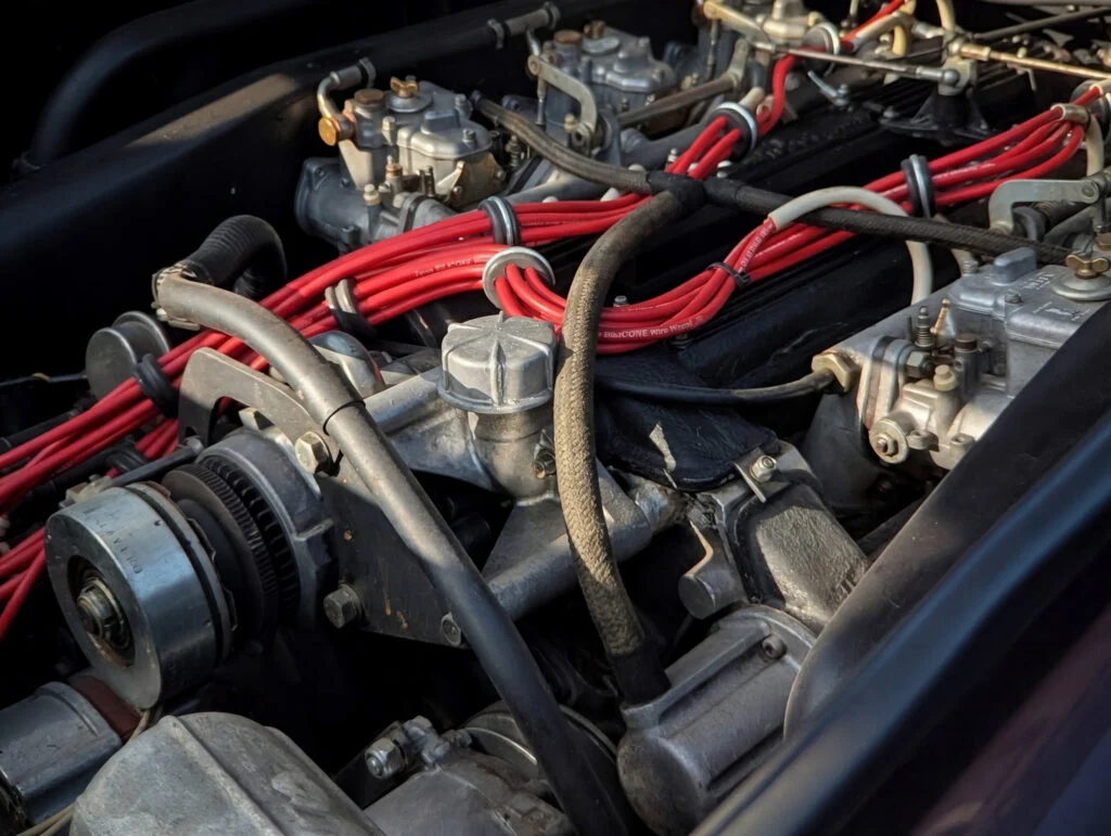 Close-up of a Lamborghini Countach 5000 QV engine bay showing carburetors and red spark plug wires.
