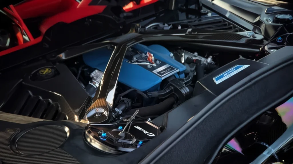 Close-up view of a Corvette ZR1 engine bay with blue engine cover and carbon fiber strut brace