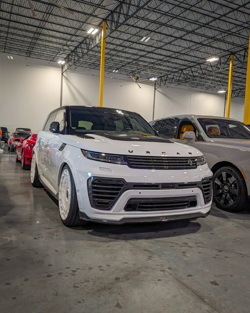 White Range Rover Urban Cruiser SUV in indoor car event with other vehicles in the background