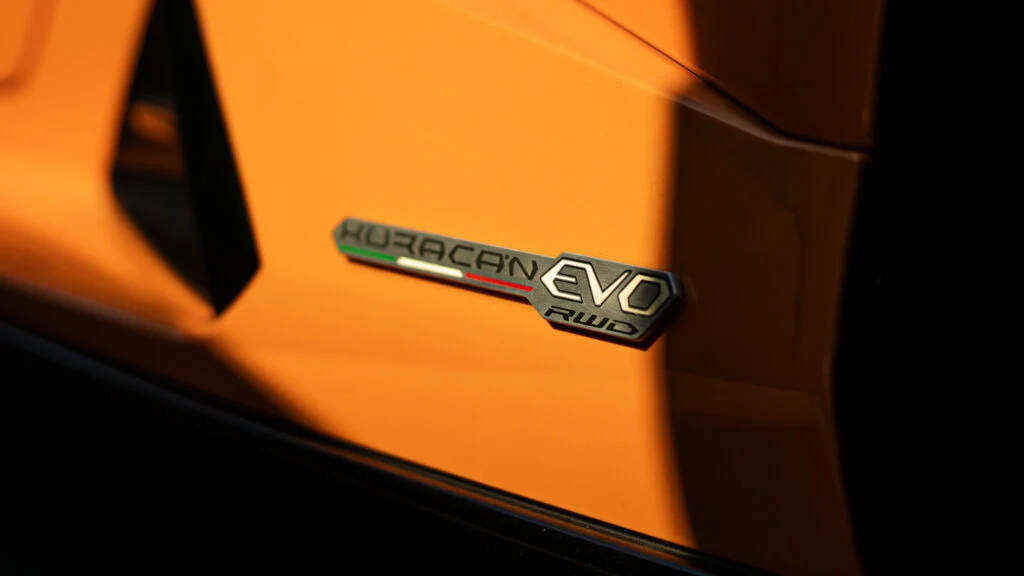 Close-up of orange Lamborghini Huracan EVO RWD badge on car exterior