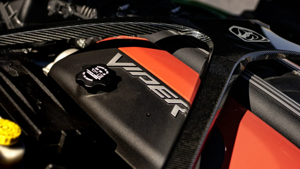 Close-up of a Viper engine cover with red and black colors and carbon fiber details