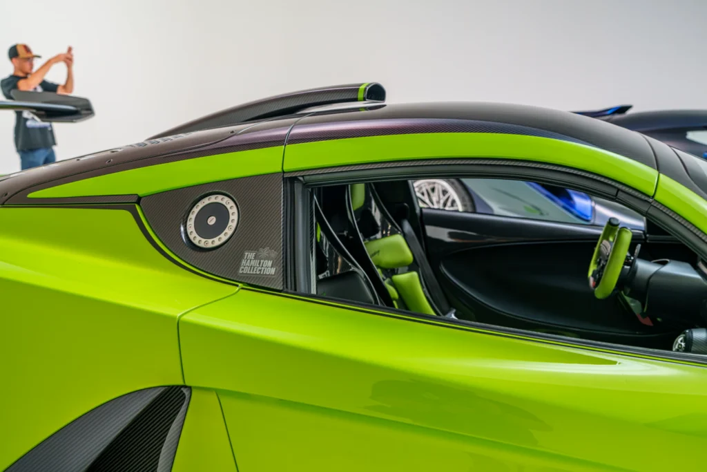 Close-up of green and carbon fiber bodywork and interior of a Hennessey Venom F5 at an indoor car event