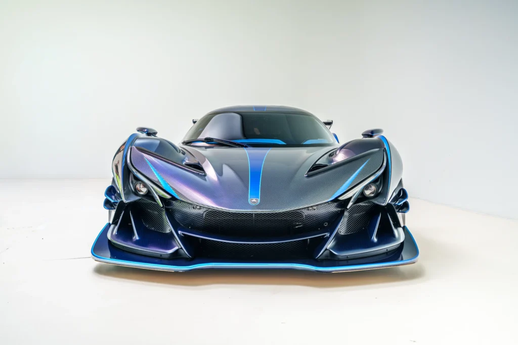 Front view of black carbon fiber Apollo IE with blue accents in a white studio setting.