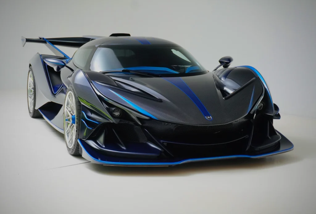 Dark blue Apollo IE sports car in studio setting, front 3/4 view showing aerodynamic body and detailing.