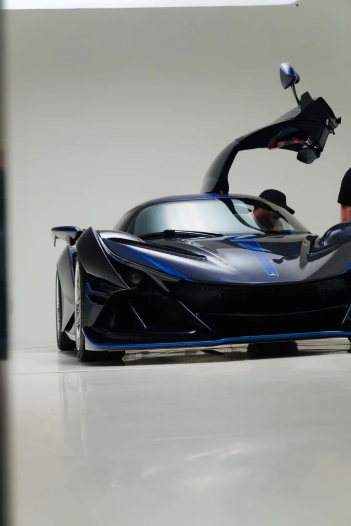 Black Apollo IE with open driver-side dihedral door in indoor setting