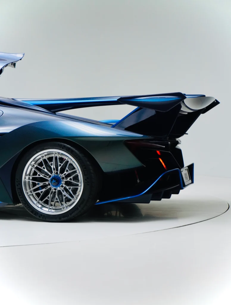 Blue Apollo IE rear wing and rear quarter with wheel and brake rotors visible in a studio setting